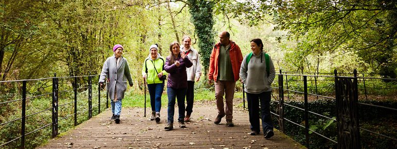 Visitors enjoying an artist led walk in woodland.
