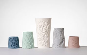 A group of ceramic vessels with intricate embossed designs of flora and fauna