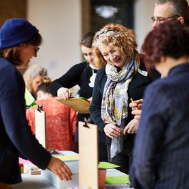 Group of people submitting forms from clipboards.