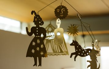 A hanging brass mobile with circus themed characters.