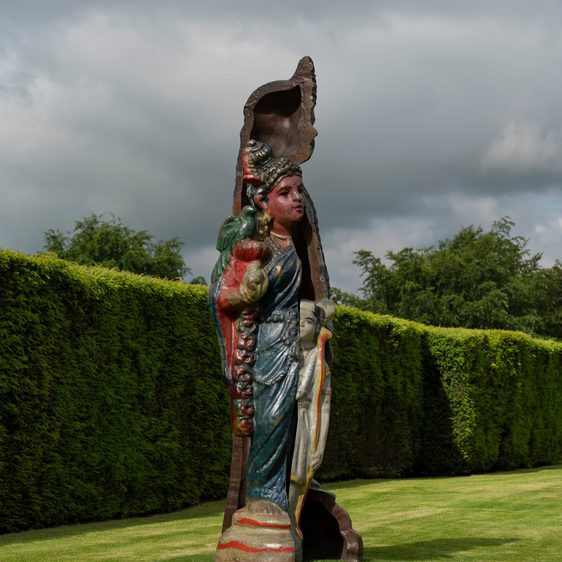 A colourful bronze sculpture of a woman dressed in a sari