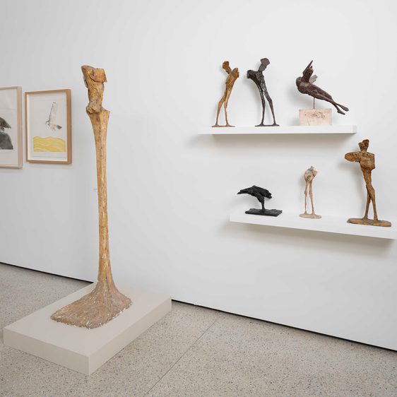 An exhibition of plaster models of animals displayed on shelves, and a to-scale model for a sculpture displayed on a plinth.