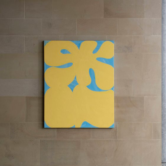 Painting hung on the wall which reads SKIN in yellow and blue