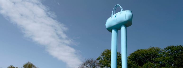Blue handbag with legs underneath a blue sky