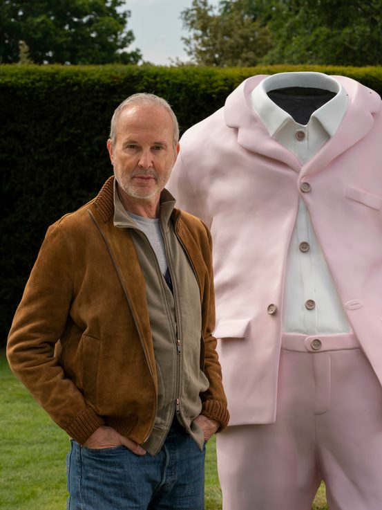 Man stood in front of sculpture of a pink suit