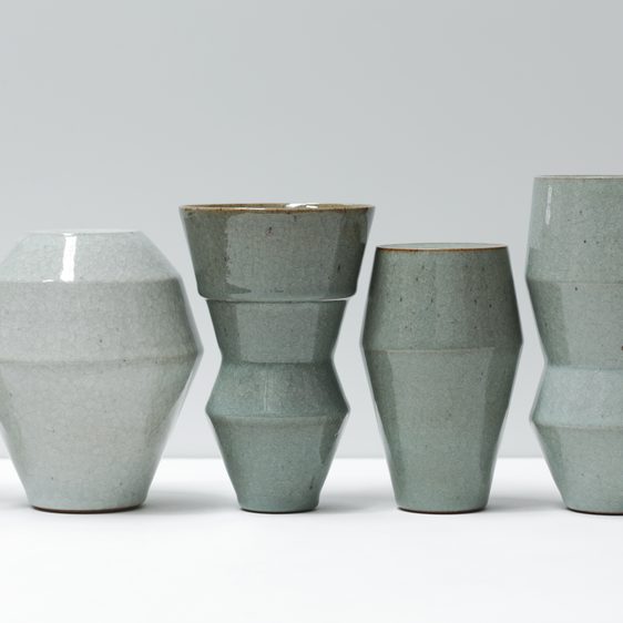 A row of green-toned ceramic vases