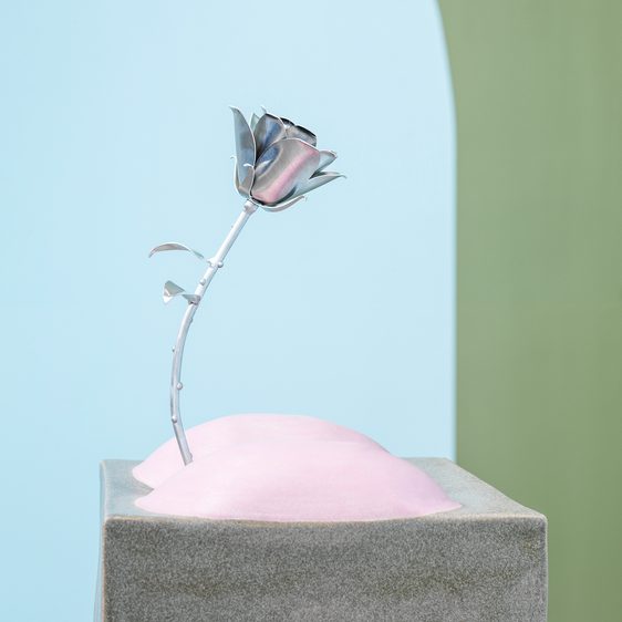 Plinth with pink bottom cheeks on top and a silver rose growing from them