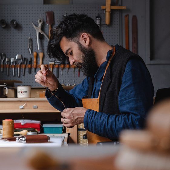A man working with tools and leather