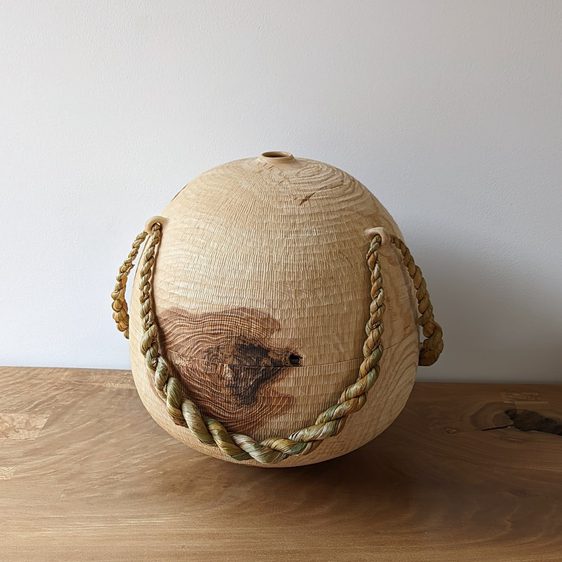 Large wooden vessel with twisted rope tied around it