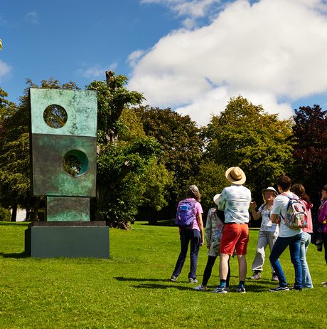 A group of people looking at contemporary sculpture outside.