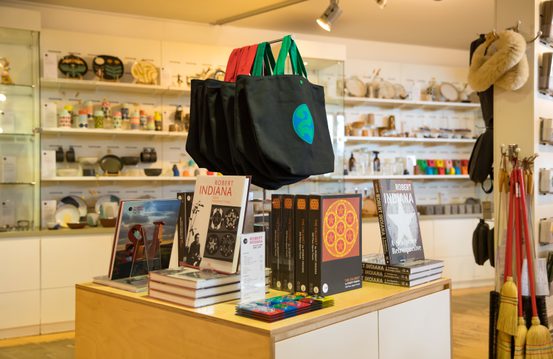 A shop display with tote bags, books and jigsaw puzzells.