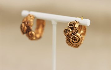 A pair of intricate gold-toned earrings