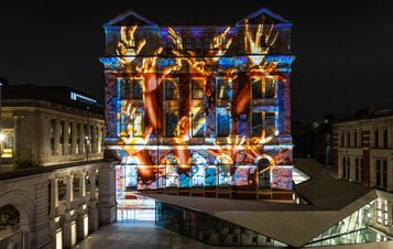 A building with a digital artwork projected onto it.