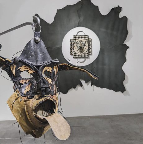 A face with protruding tongue and hat made out of leather